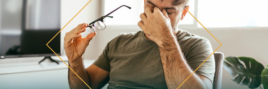 a man holding his glasses and pinching his nose