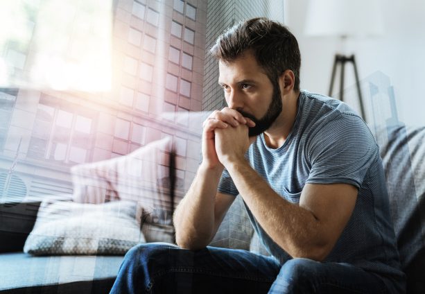 Man sitting on sofa in deep thought