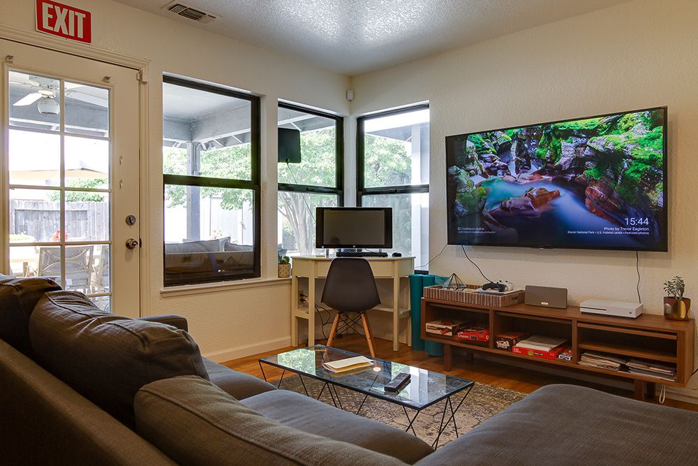 Living room with a couch, TV, computer and door to an outdoor patio