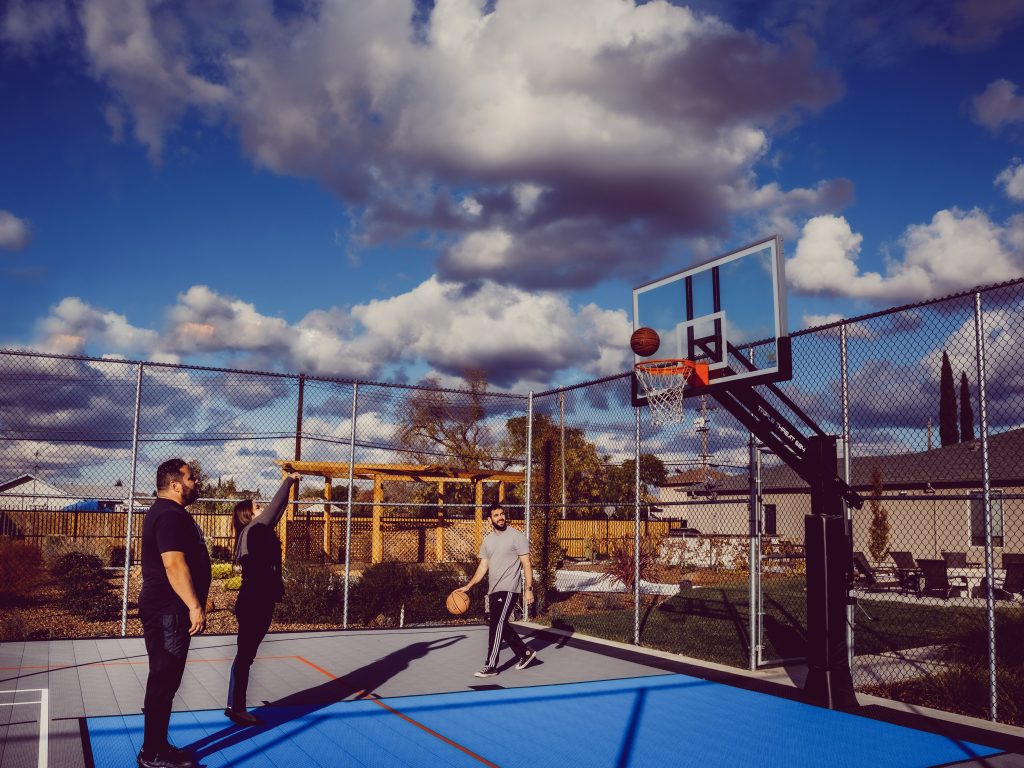 Three people playing basketball outside