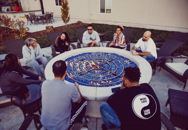 Group of people talking around a fire pit
