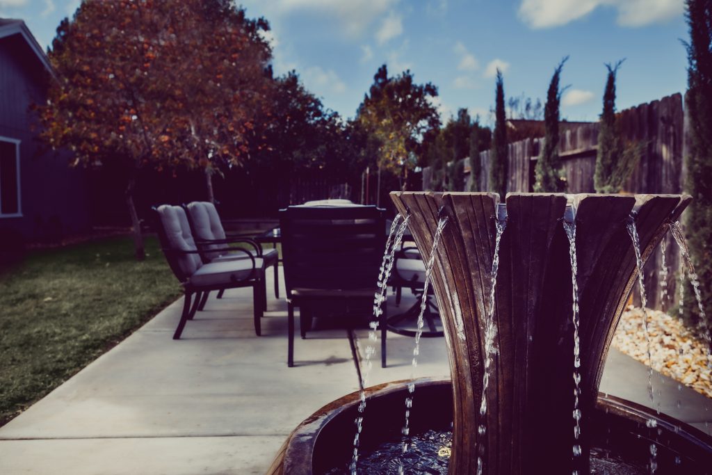 Wooden fountain and an outdoor patio table with chairs