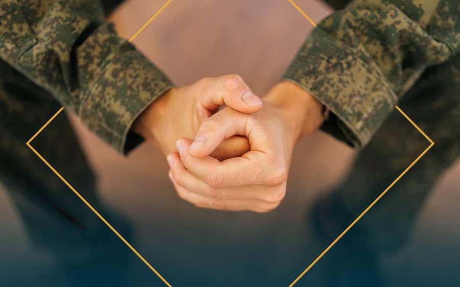 person in a military uniform with folded hands